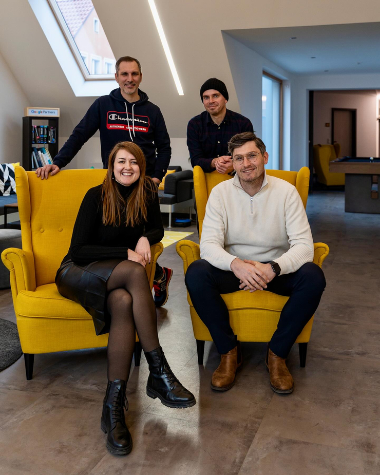 C3 ernennt Chief Operating Officer (COO) und Chief Creative Officer (CCO) Gruppenfoto in der Lounge der C3 marketing agentur: Anja Meixner und Alexander Schirmer sitzen vorne in gelben Sesseln, hinter ihnen stehen Thomas Franz und Christian Reisnecker. Das Bild zeigt das erweiterte Führungsteam in entspannter Atmosphäre.