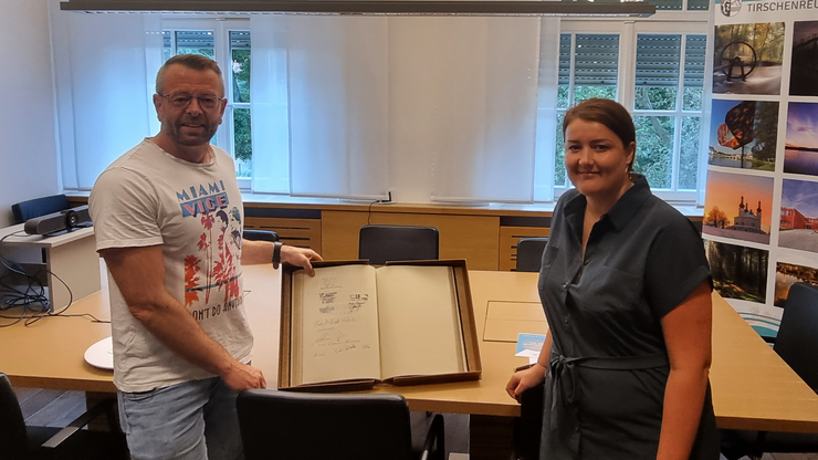 Ehrung für das C3-Team: Eintrag ins goldene Buch des Landkreises Tirschenreuth Christian Walter und Anja Meixner stehen im Landratsamt Tirschenreuth vor einem aufgeschlagenen goldenen Buch, in das sie sich stellvertretend für das C3-Team eintragen durften. Anlass ist die Umsetzung einer barrierefreien Info-Stehle im Innenhof der Behörde.
